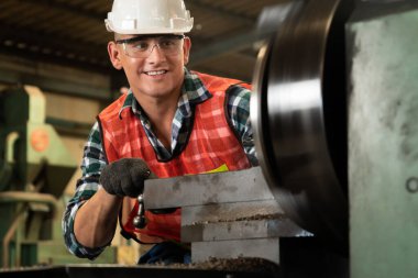 Akıllı fabrika işçisi veya mühendisi bir imalat atölyesinde makine işi yapıyor.