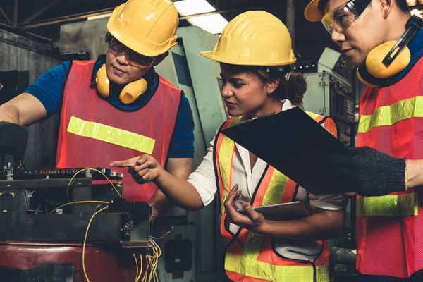 Grupo de trabalhadores habilidosos usando equipamentos de máquinas na oficina de fábrica — Fotografia de Stock