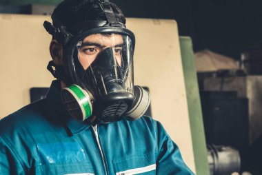 Yetenekli işçiler fabrikada gaz maskesi takarlar. .