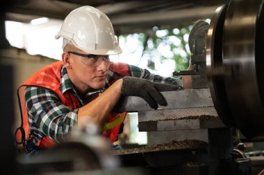 Akıllı fabrika işçisi veya mühendisi bir imalat atölyesinde makine işi yapıyor.
