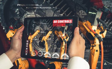 Mühendis, artırılmış gerçeklik endüstrisi teknolojisiyle robotik kolları kontrol ediyor.