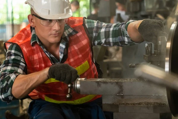 Akıllı fabrika işçisi veya mühendisi bir imalat atölyesinde makine işi yapıyor.