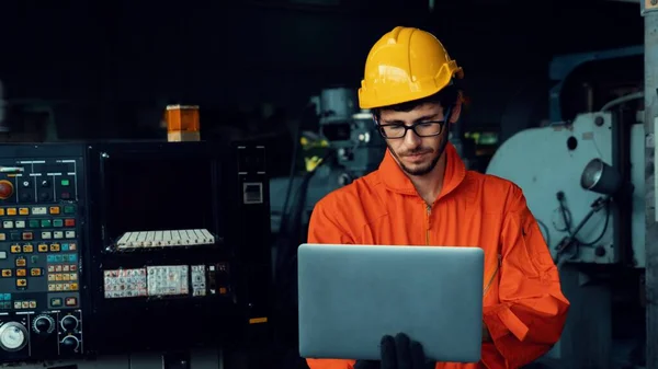 Trabalhador de fábrica hábil trabalhando com computador portátil para fazer a lista de verificação do procedimento . — Fotografia de Stock