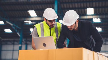Fabrikada çalışan ve üretim planını tartışan iki fabrika işçisi. .