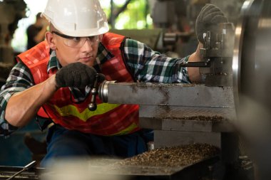 Akıllı fabrika işçisi veya mühendisi bir imalat atölyesinde makine işi yapıyor.