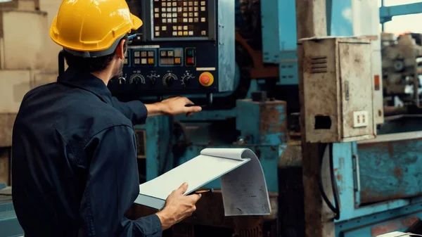 Умілий заводський працівник, який працює з кишені, щоб виконати контрольний список процедур роботи  . — стокове фото