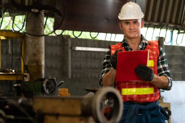 İş prosedürü kontrol listesi için pano ile çalışan imalat işçisi .