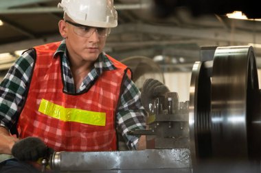 Akıllı fabrika işçisi veya mühendisi bir imalat atölyesinde makine işi yapıyor.