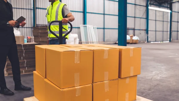 Trabalhadores da fábrica entregar caixas pacote em um carrinho de empurrar no armazém . — Fotografia de Stock