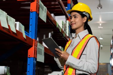 Depoda çalışan kadın bir depo işçisi.