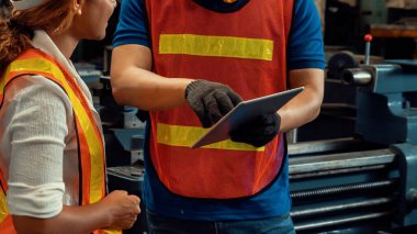 Tablet bilgisayarda projeyi tartışan iki yetenekli fabrika mühendisi veya işçi