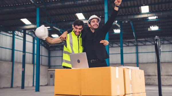 Two factory worker celebrate success together in the factory