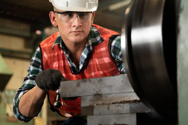 Akıllı fabrika işçisi veya mühendisi bir imalat atölyesinde makine işi yapıyor.