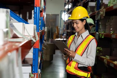 Depoda çalışan kadın bir depo işçisi.