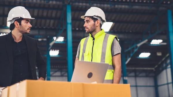 Två fabriksarbetare arbetar och diskuterar tillverkningsplan i fabriken . — Stockfoto