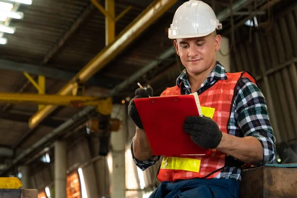 Trabajador de fabricación que trabaja con portapapeles para hacer la lista de verificación del procedimiento de trabajo . — Foto de Stock