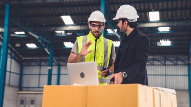 Fabrikada çalışan ve üretim planını tartışan iki fabrika işçisi. .