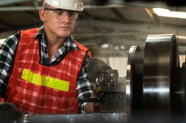 Akıllı fabrika işçisi veya mühendisi bir imalat atölyesinde makine işi yapıyor.