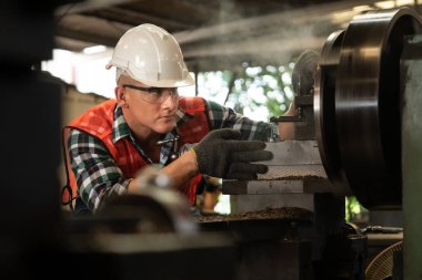 Akıllı fabrika işçisi veya mühendisi bir imalat atölyesinde makine işi yapıyor.