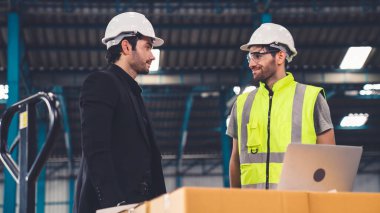 Fabrikada çalışan ve üretim planını tartışan iki fabrika işçisi. .