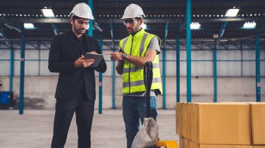 Fabrikada çalışan ve üretim planını tartışan iki fabrika işçisi. .