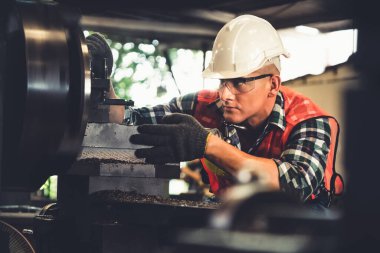 Akıllı fabrika işçisi veya mühendisi bir imalat atölyesinde makine işi yapıyor.