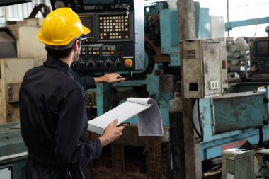 İşlemleri kontrol etmek için pano ile çalışan yetenekli bir fabrika işçisi. .