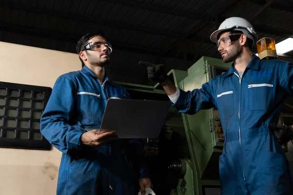 Gruppo di operai qualificati che utilizzano attrezzature per macchine in officina — Foto Stock