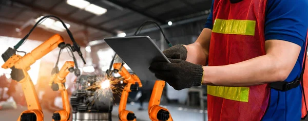 Ingeniero utiliza software robótico avanzado para controlar brazo robot de la industria en fábrica — Foto de Stock