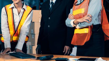 Depo müdürü ve işçisi depoda çalışıyor.