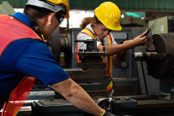 Group of skillful workers using machine equipment in factory workshop