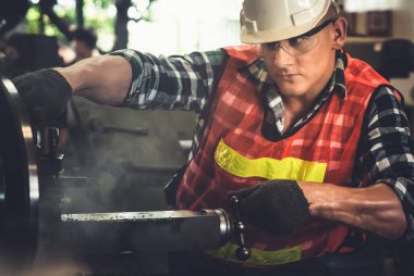 Akıllı fabrika işçisi veya mühendisi bir imalat atölyesinde makine işi yapıyor.
