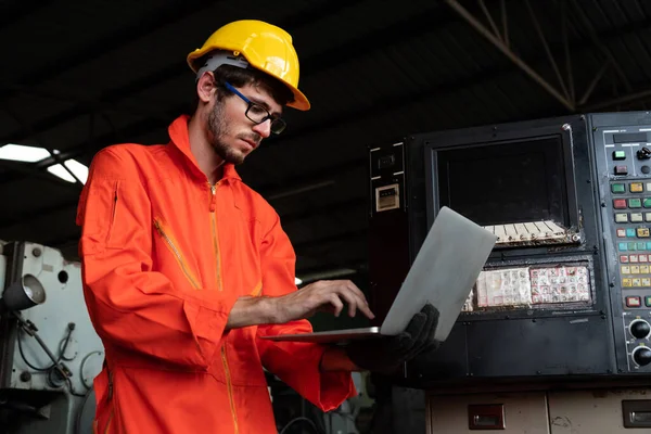 Trabajador hábil de la fábrica que trabaja con la computadora portátil para hacer la lista de verificación del procedimiento . — Foto de Stock