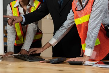 Depo müdürü ve işçisi depoda çalışıyor.