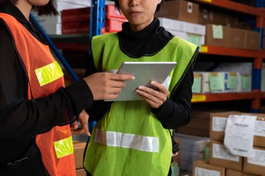 Depoda çalışan kadın bir depo işçisi.