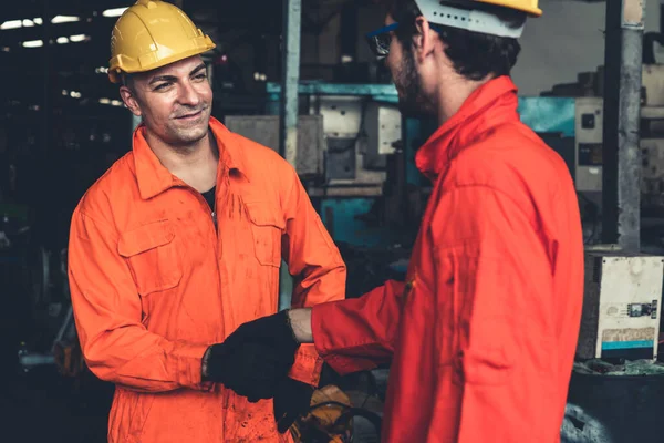 Dos hábiles ingenieros de fábrica o trabajadores que muestran trabajo en equipo y asociación . — Foto de Stock