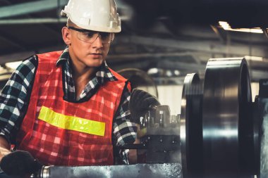 Akıllı fabrika işçisi veya mühendisi bir imalat atölyesinde makine işi yapıyor.