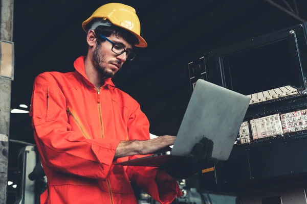 Skillful factory worker working with laptop computer to do procedure checklist .