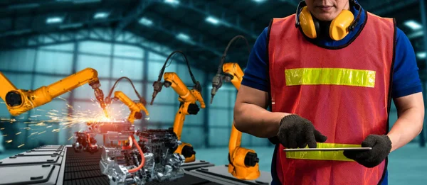 Engineer use advanced robotic software to control industry robot arm in factory