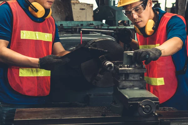 Grupp skickliga fabriksarbetare som använder maskinutrustning i verkstaden — Stockfoto