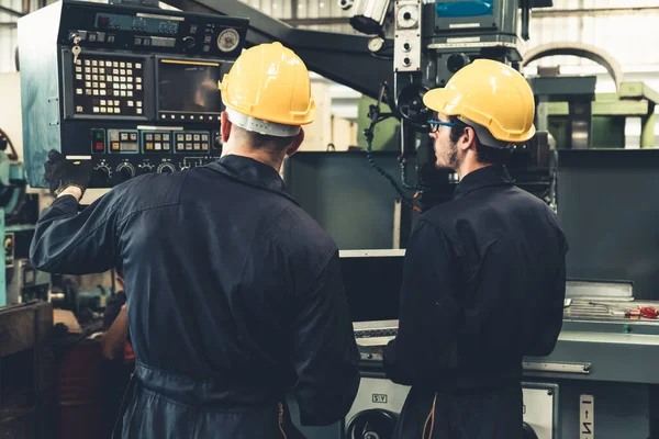 Grupo de trabalhadores de fábrica habilidosos usando equipamentos de máquinas em oficina — Fotografia de Stock