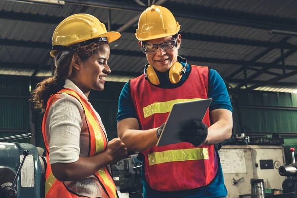 Dos hábil ingeniero de fábrica o trabajador discutiendo proyecto en la computadora tableta —  Fotos de Stock