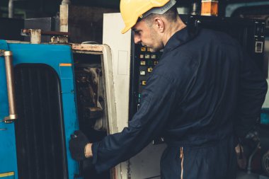 Fabrika mühendisi veya işçisi üretim atölyesinde makine işi yapıyor.