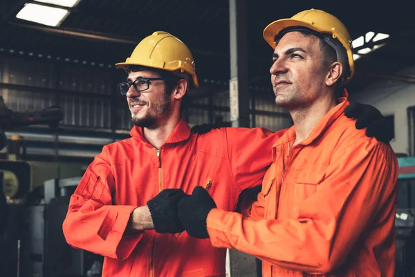 Dos hábiles ingenieros de fábrica o trabajadores que muestran trabajo en equipo y asociación . — Foto de Stock