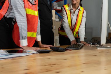 Depo müdürü ve işçisi depoda çalışıyor.