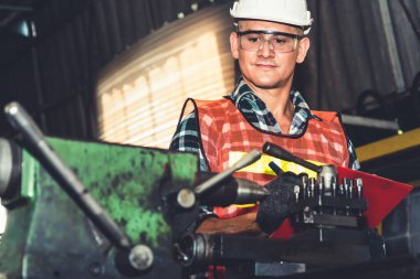 Akıllı fabrika işçisi veya mühendisi bir imalat atölyesinde makine işi yapıyor.