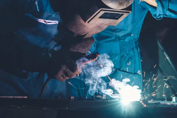Geschickter Metallarbeiter arbeitet mit Lichtbogenschweißmaschine in Fabrik — Stockfoto
