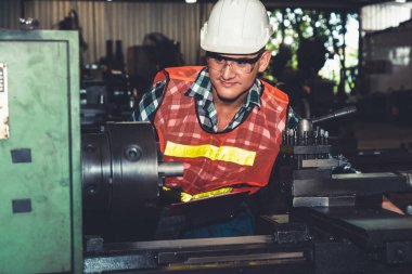 Akıllı fabrika işçisi veya mühendisi bir imalat atölyesinde makine işi yapıyor.