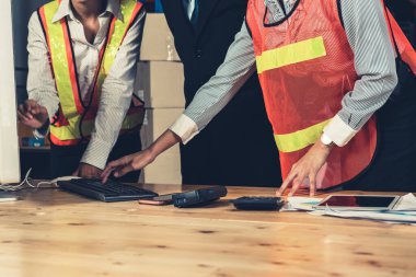 Depo müdürü ve işçisi depoda çalışıyor.