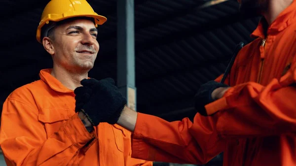 Dos hábiles ingenieros de fábrica o trabajadores que muestran trabajo en equipo y asociación . — Foto de Stock